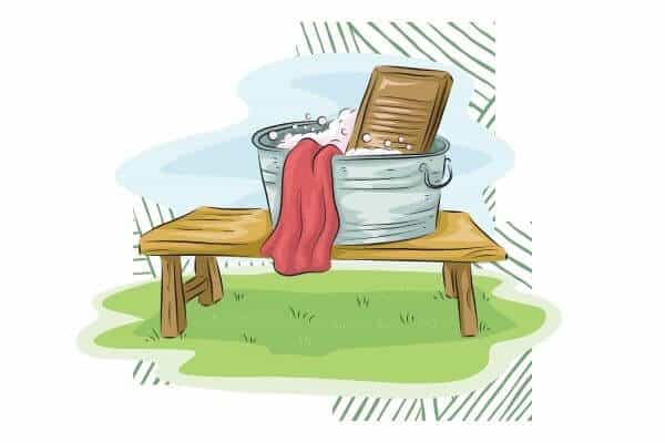 A graphic of a bench with a metal laundry tub filled with dirty laundry, water and a washboard